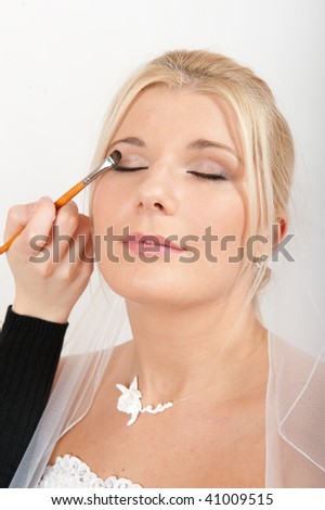 stock photo Young sexy bride applying wedding eye make up by professional 