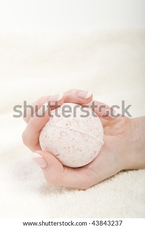 Beautiful hand with perfect french manicure and strong nails holding round soap