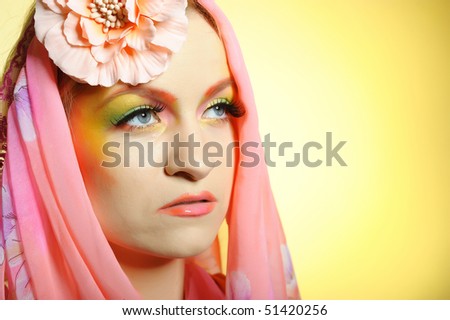 Close-up portrait of summer beautiful woman with fashion creative eye make-up in yellow and green tones. copy-space