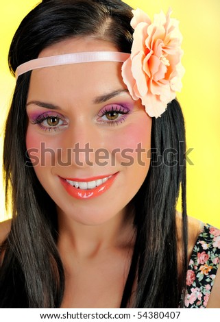Young beautiful woman face with creayive eye make-up and flower band in the hair