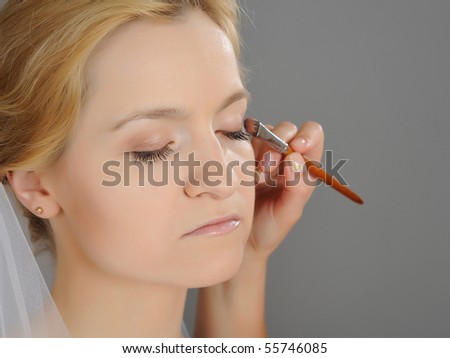 stock photo Natural Wedding makeup is being applied to pretty bride gray