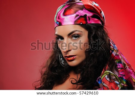 Beautiful gypsy woman with bright make-up. red background
