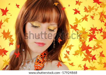 Beautiful autumn fairy woman with golden make-up. falling leaves background
