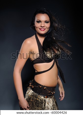 Beautiful sexy bellydancer woman with oriental make-up and red lips dancing and smiling