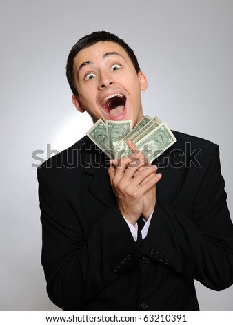 Expressions - Young handsome business man in black suit and tie counting money. gray background