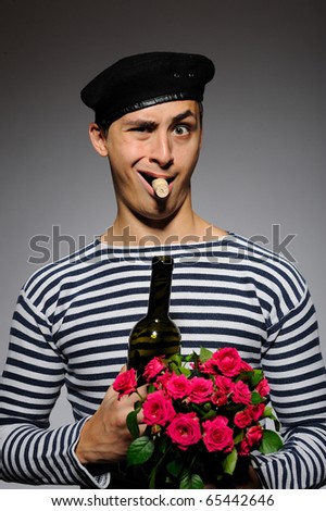 Funny romantic sailor man opening bottle and holding rose flowers prepared for a date