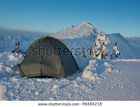 a tent is pitched in snow with Mt. Baker in Washington State in background