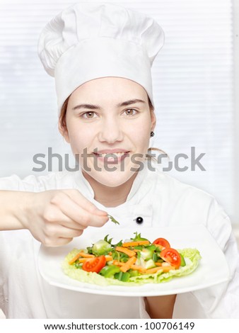 pretty young chef decorating delicious salad