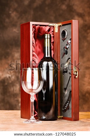 Wine bottle and cup in front of wooden wine case