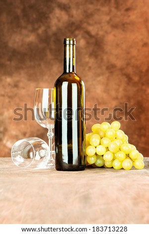 Wine bottle and shiny wine cup near grape