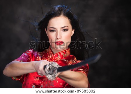 Pretty kimono woman in action with katana/sword
