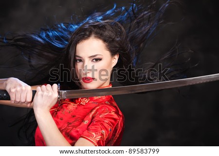 Pretty kimono woman in action with katana/sword