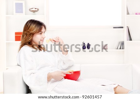 teenager girl at home eating chips and relaxing