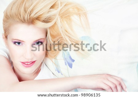 Pretty blond woman with blue eyes on pillow
