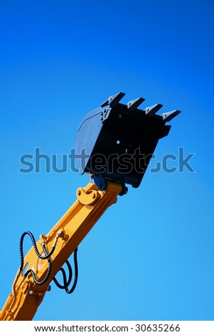 excavator arm against blue sky