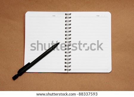 Open blank note book on brown paper.