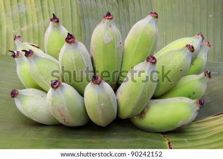 Raw bananas on a banana leaf.
