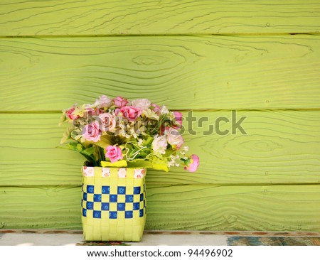 Vase with Plastic flowers and green wall