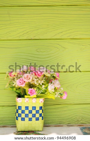 Vase with Plastic flowers and green wall