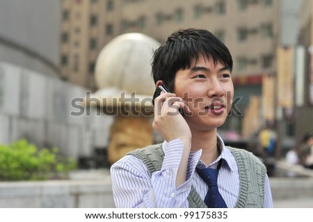 asian young businessman using mobile phone,outdoors