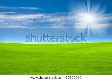 Blue sky and green field with sun effect