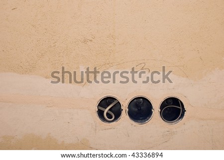 Professional installation of three electric sockets on old wall background