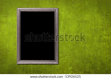 Silver frame on a green wall background