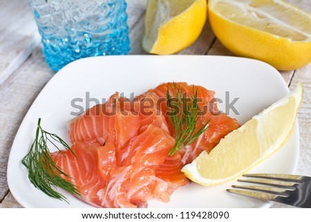 Salmon on white plate with lemon  on white background. Selective focus.