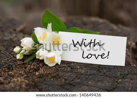 Postcard with fresh flowers and tag with words with love