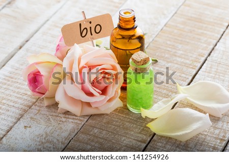 Essential aroma oil from roses  on wooden background. Organic/bio product. Selective focus.