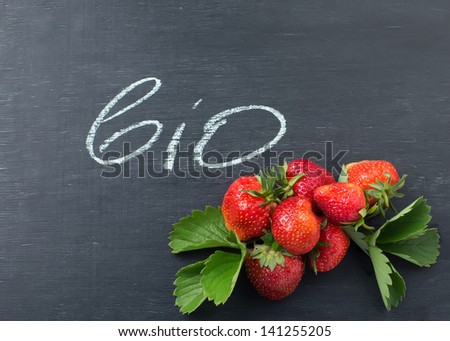 Fresh organic strawberry on blackboard with word bio. Natural/organic/bio product.