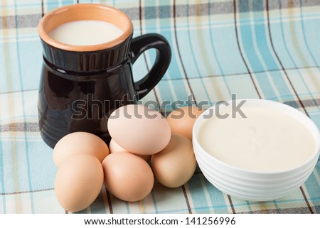Fresh dairy products - milk, sour cream, eggs. Rustic style. Bio/organic/natural ingredients. Healthy eating.