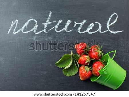 Fresh organic strawberry on blackboard with word natural. Natural/organic/bio product.