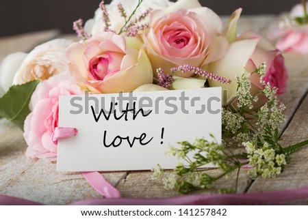 Postcard with fresh flowers and tag with words with love
