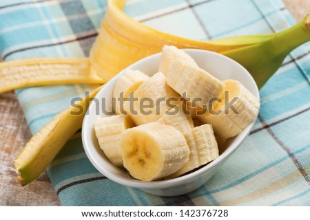 Fresh organic banana in bowl  on wooden background. Selective focus. Rustic style.
