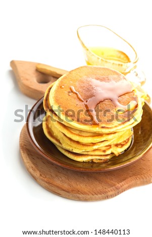 Appetizing pancakes on plate with honey/syrup isolated on white background. Healthy breakfast. Selective focus.