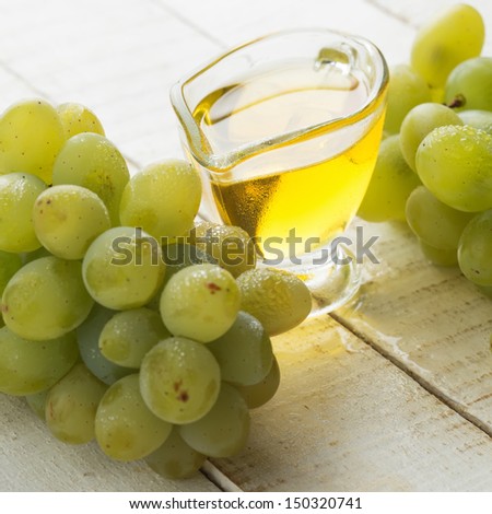 Grape seed oil on white wooden background. Selective focus. Bio/organic/eco products.