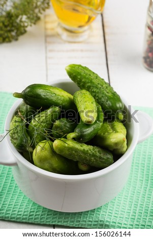 Fresh organic cucumbers in bowl on white wooden table. Selective focus. Natural/organic/bio/healthy products.