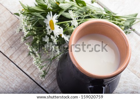 Milk in pitcher on white wooden background. Selective focus. Concept natural products.