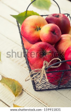 Fresh apples in metallic bucket on white wooden  background. Selective focus.