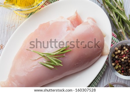 Fresh chicken meat on plate on white table with spices. Selective focus. Rustic style.
