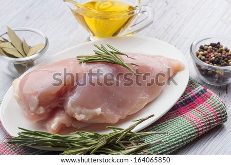 Fresh chicken meat on plate on white wooden  table. Selective focus. Rustic style.