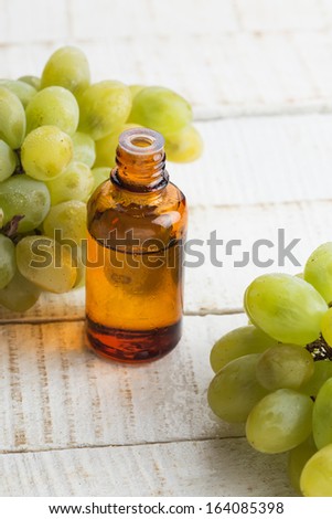 Grape seed oil in bottle on white wooden background. Selective focus. Bio/organic/eco products.