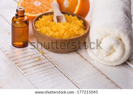 Orange spa. Sea salt, aroma oil with orange on white wooden background. Selective focus.