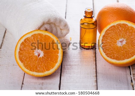 Essential aroma oil with oranges on wooden background. Spa concept. Selective focus.