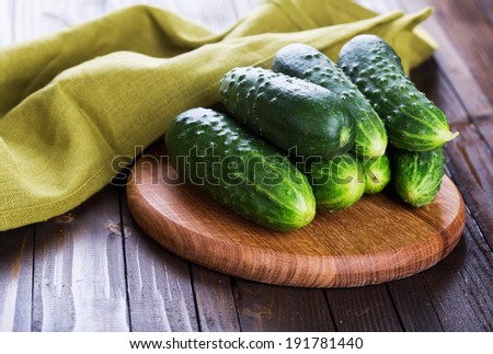 Fresh organic cucumbers on board  on wooden table. Selective focus, horizontal. Natural/organic/bio/healthy products.