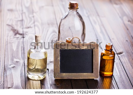 Bottles with aroma oil, medicines and empty blackboard  on wooden background. Selective focus, horizontal.