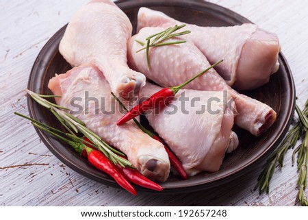 Fresh chicken meat on plate  on white table. Selective focus, horizontal. Rustic style.