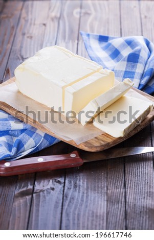Fresh organic butter on board on wooden background. Rustic style. Bio/organic/natural ingredients. Healthy eating.