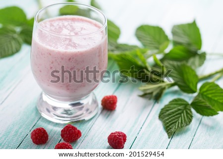 Smoothie drink with raspberry  on aqua background. Selective focus, horizontal.